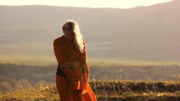 Blond meisje op de winderige heuvel — Stockvideo