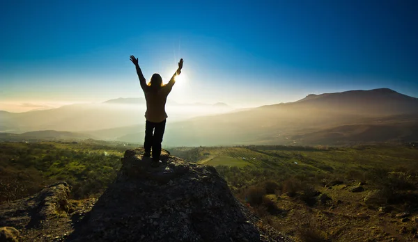 Girl with hands up in the mountsins against sun — Stock Photo, Image