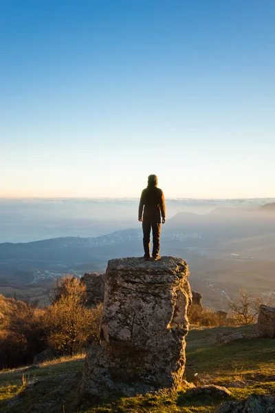 Άνθρωπος πάνω στο βράχο, στα βουνά στο ηλιοβασίλεμα — Φωτογραφία Αρχείου
