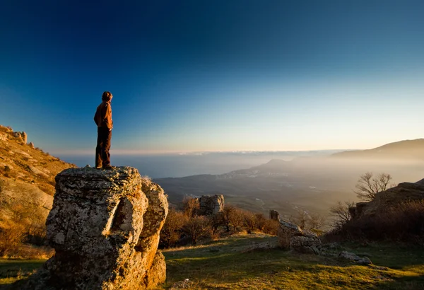 Omul de pe stâncă în munţi la apusul soarelui — Fotografie, imagine de stoc