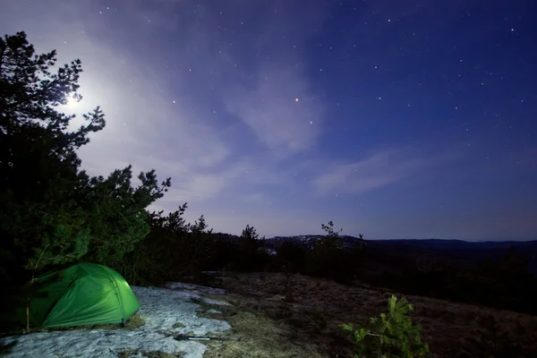 Moon över bergen med tält belyst — Stockfoto