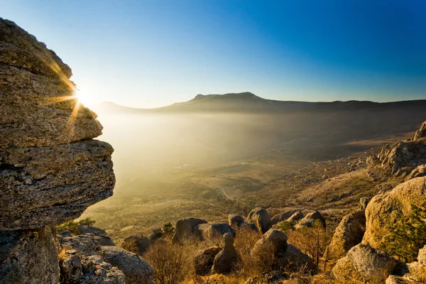 阳光照耀在日落时分在山中的石头 — 图库照片