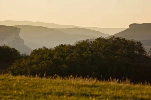 Fundo montanhas em camadas ao nascer do sol — Fotografia de Stock