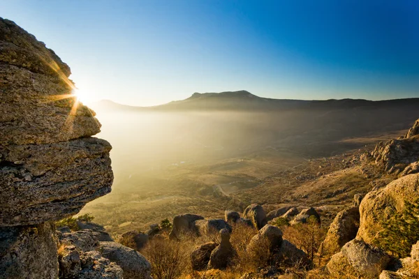 Sunbeam shining above stone in mountains at sunset — Stock Photo, Image