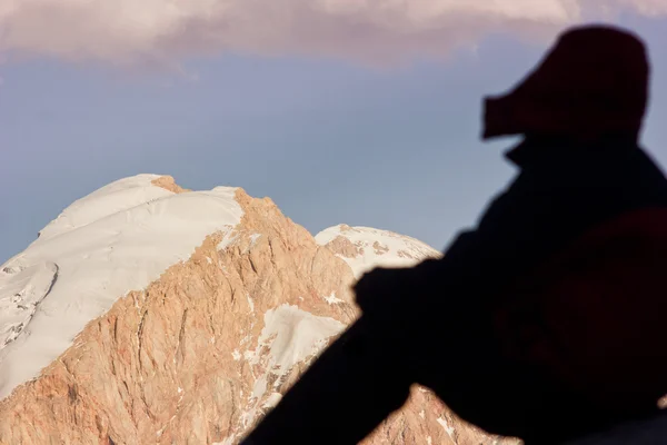 Oturma ve bir dağda izlerken kadın — Stok fotoğraf