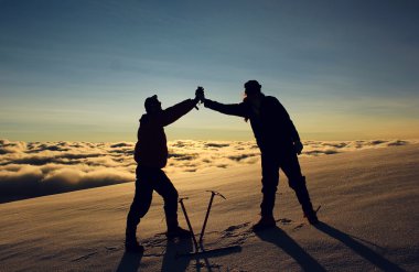 Beş dakika mola ile dağlarda karlı bir yamaç üzerinde duran insanlar