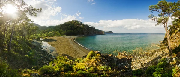 Soluppgång på lång strand som omges av berg — Stockfoto