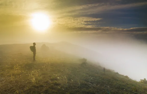 Az ember állandó ködös Időjárás egy dombon napnyugtakor — Stock Fotó