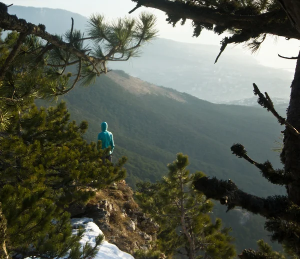 Man standing on a cliff in mountains at sunrise — Stock Photo, Image