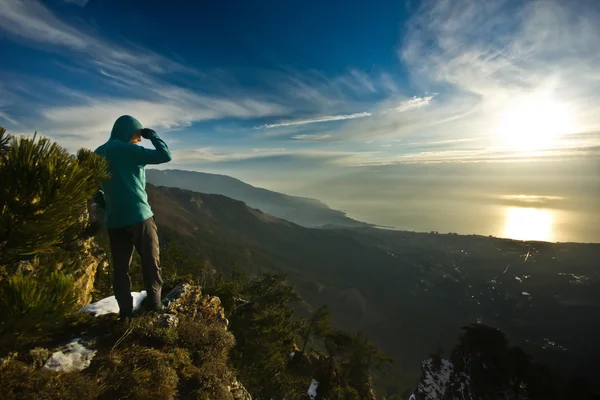 Omul stând pe o stâncă în munţi la răsăritul soarelui — Fotografie, imagine de stoc