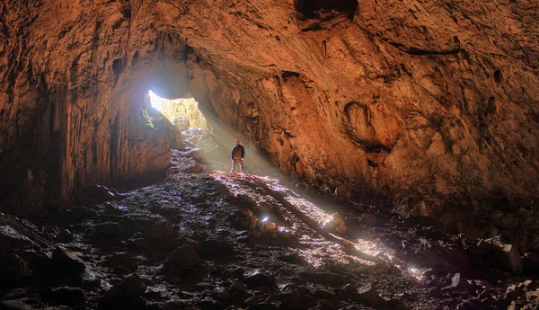 Große Höhle mit kleinen Menschen- und Sonnenstrahlen darin — Stockfoto