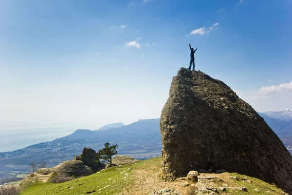 Man on the cliff in mountains at above sea — Stock Photo, Image