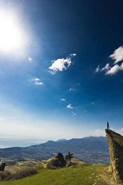 Man on the cliff in mountains at above sea — Stock Photo, Image