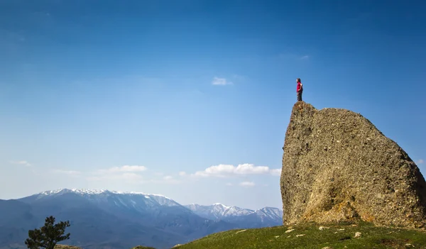 Людина на скелі в горах над морем — стокове фото