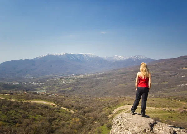 Chica de pie en un acantilado en las montañas —  Fotos de Stock