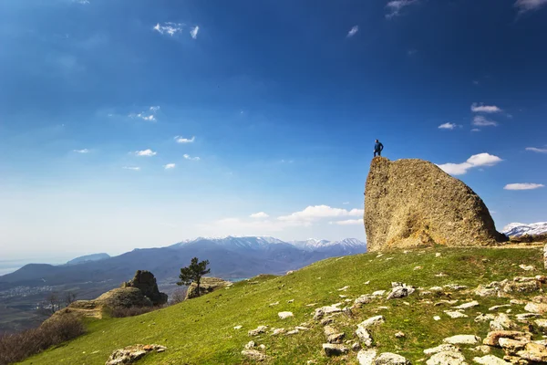 Людина на скелі в горах над морем — стокове фото