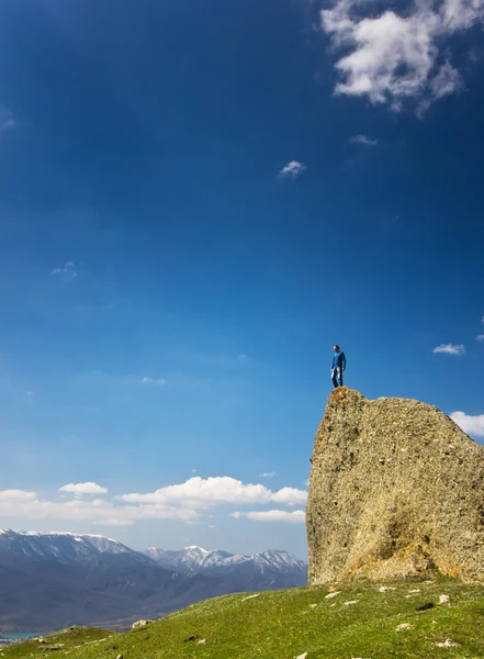 Man on the cliff in mountains at above sea — Stock Photo, Image