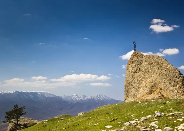 Hombre en el acantilado en las montañas en el mar — Foto de Stock