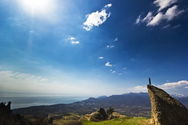 Man på klippan i bergen på ovanför havet — Stockfoto