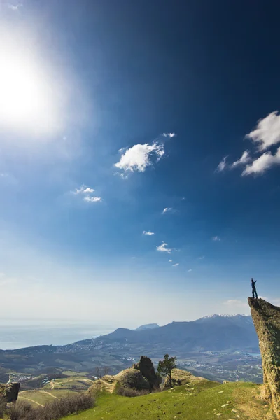 Man on the cliff in mountains at above sea — Stock Photo, Image