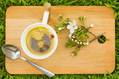 çim arka plan ile kesme tahtası üzerinde bitki çayı