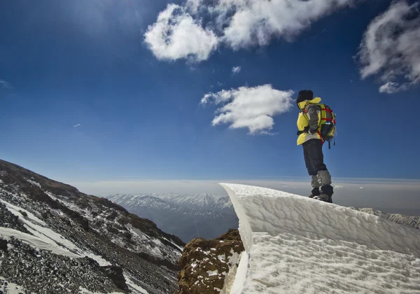 Uomo in piedi su una cornice di neve in montagna alba — Foto Stock