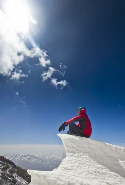 山の日の出に雪庇に坐っていた男 — ストック写真