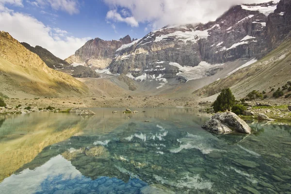 Blauwe bergmeer omgeven door hoge pieken bij zonsondergang — Stockfoto