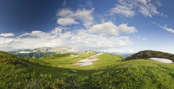 Панорама летних снежных гор с большой травяной долиной — стоковое фото