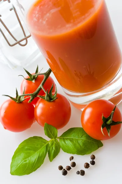 Tomates rojos frescos con hojas de albahaca y jugo — Foto de Stock