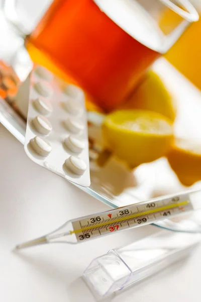 Чай з лимонами та таблетками від грипу з термометром - засіб від зчеплення — стокове фото