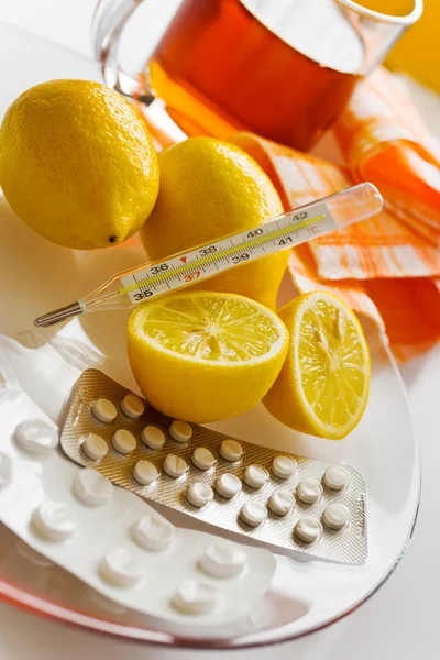 Te med citroner och influensa piller med termometer - grippe remedy — Stockfoto