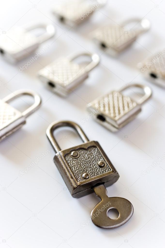 Rows of padlocks on white background - open lock