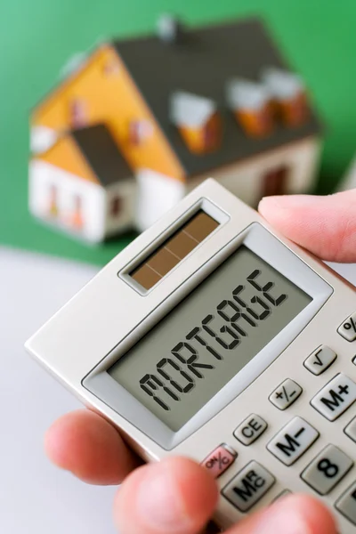 Family house and  hand holding a pocket calculator with Mortgage — Stock Photo, Image