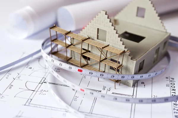 New model house with scaffolding on architecture blueprint plan — Stock Photo, Image