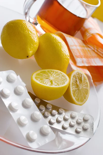 Черный чай со свежими лимонами и таблетками от гриппа в блистере — стоковое фото