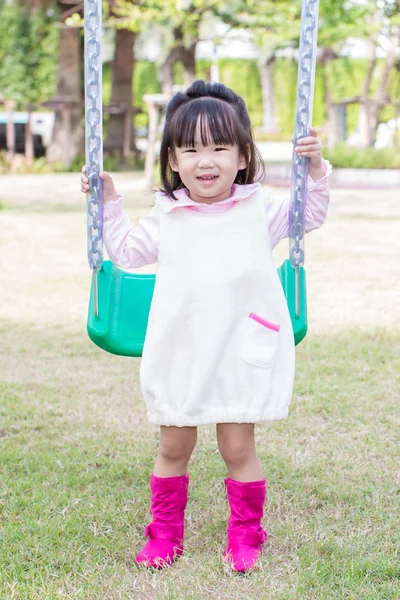 Little asian girl play swing in the playground — Stock Photo, Image