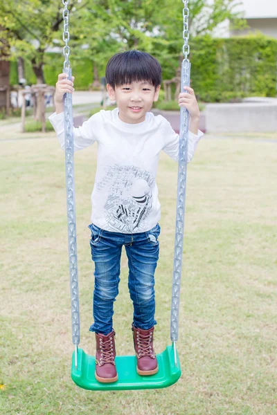 Little asian boy play swing in the playground — Stock Photo, Image