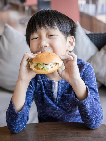 Küçük Asyalı çocuk hamburger yemek