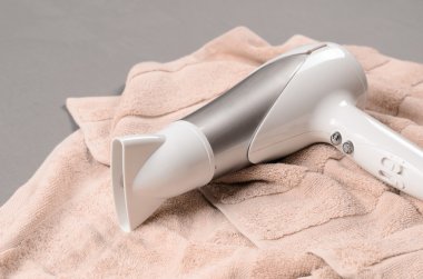 Beyaz saç üzerinde bej havlu kurutma makinesi