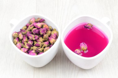 İki bardak çay gül ahşap bir masa üzerinde beyaz