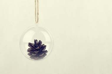 İçinde bir çam kozalağı ile şeffaf Noel top
