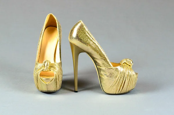 Gold high-heeled shoes on  a gray background — Stock Photo, Image