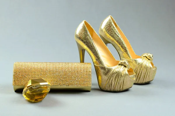 Zapatos de tacón alto de oro, bolso de embrague y perfume en un fondo gris —  Fotos de Stock