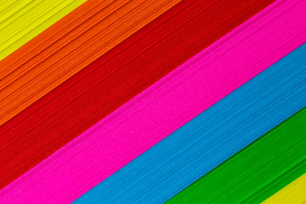 Multicolored sticky notes stacked in a pile. Evenly lit by artificial light