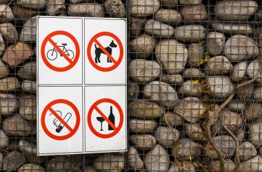 Taş duvarda tabela var. Köpek yok, bisiklet yok, sigara yok, alkol yok.