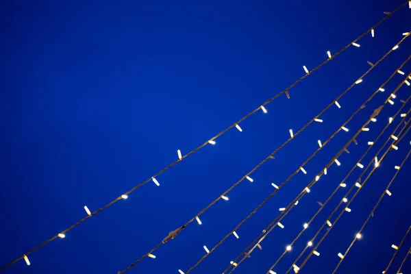 Akşam gökyüzünün arka planında neşeli hafif çelenkler