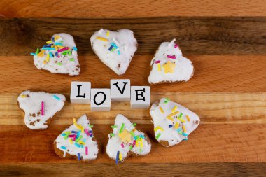 Kalpli zencefilli ekmeklerden oluşan bir kompozisyon ve tahta bir tahtanın üzerine dizilmiş 