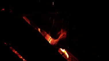 Geceleyin sönen bir yangında parlayan odunlar