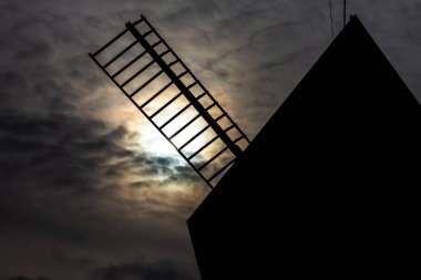 Kırsal bir açık hava müzesinde ahşap yel değirmeni. Gün ortasında çekilen sergi, gece mevsimi gibi görünmeye ayarlandı.. 